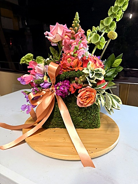 Moss handbag bouquet with peach ribbon