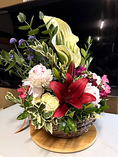 Basket arrangement with hosta and lily
