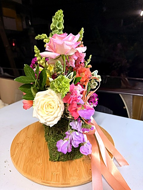 Moss handbag arrangement with peach ribbon