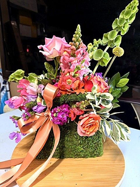 Moss handbag bouquet with peach ribbon bow